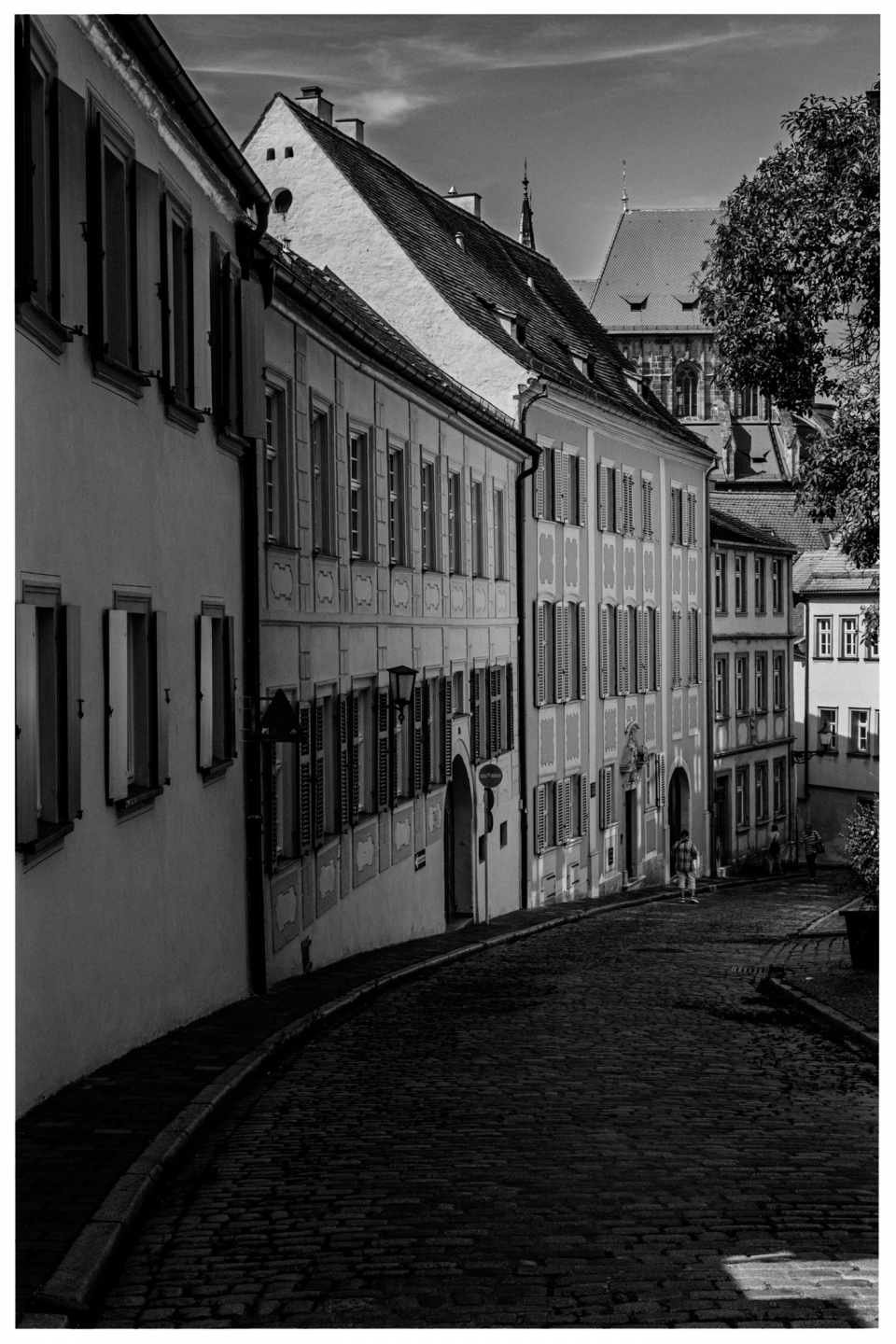 Historische gepflasterte Straße mit Gebäuden, shuttered Fenstern, Kirche im Hintergrund, Menschen, © Klaus Gruber | dolphin photography