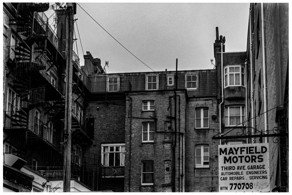 Backsteingebäude mit Feuerleiter und "MAYFIELD MOTORS"-Schild für nahegelegene Garage, © Klaus Gruber | Fotograf Fürth