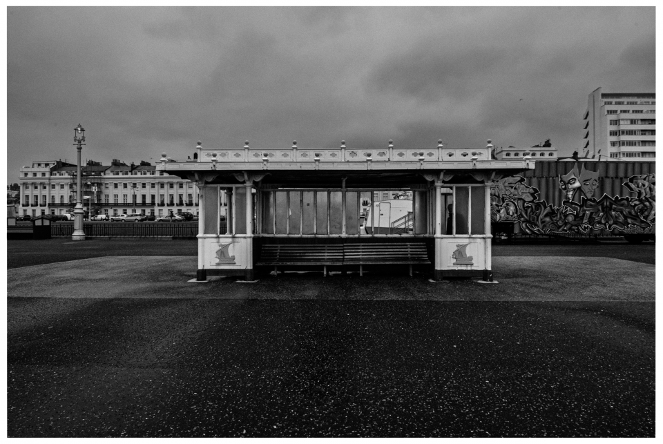 Altes Wartehäuschen mit Fenster auf leerer Straße, Gebäude und Graffiti im Hintergrund, schwarz-weiß, © Klaus Gruber | Fotograf Fürth