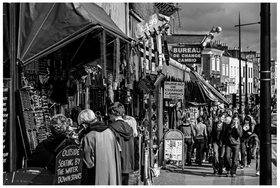 Belebte Straße mit Marktstand, Gürtel und Accessoires, Menschen flanieren, Schwarz-Weiß-Foto, © Klaus Gruber | Fotograf Fürth