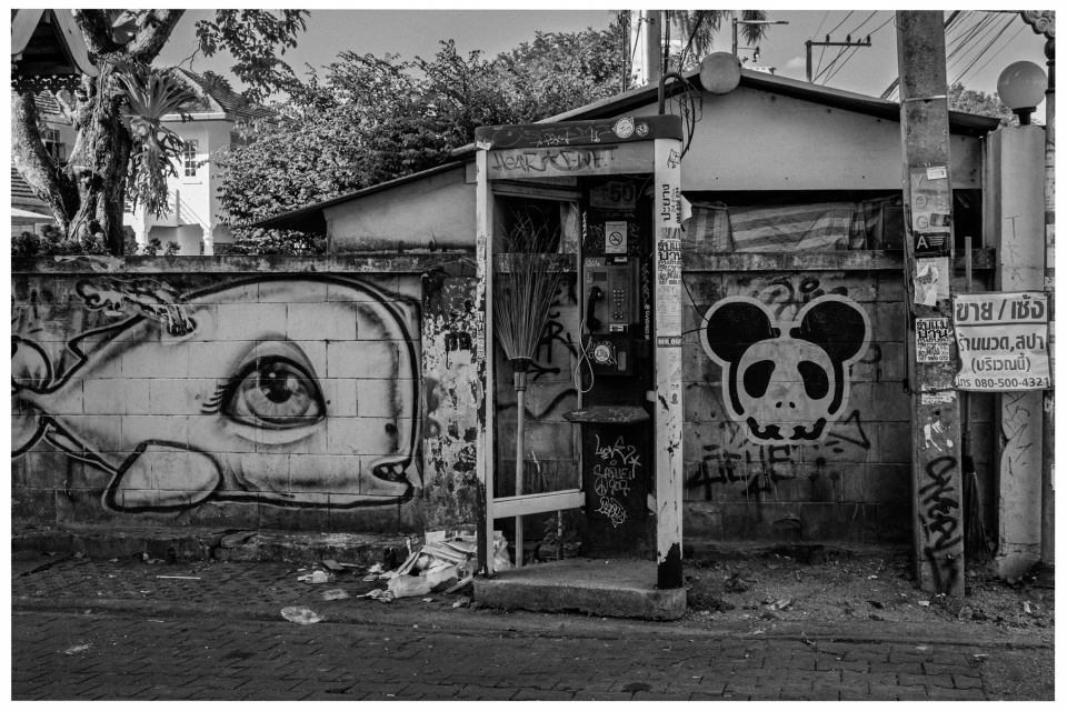 Alte Telefonzelle vor Graffiti-Wand mit Fisch- und Pandaabbildung, Straßenansicht, schwarz-weiß, © Klaus Gruber | Fotograf Fürth