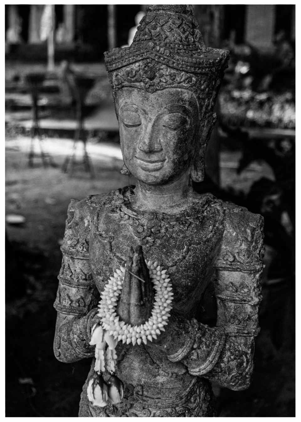 Steinerne Statue einer Figur mit Blumenkranz, geschlossenen Augen und gefalteten Händen, © Klaus Gruber | Fotograf Fürth